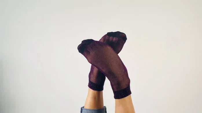 Sheer purple socks styled with rolled-up jeans on crossed legs, Love Classic fashion