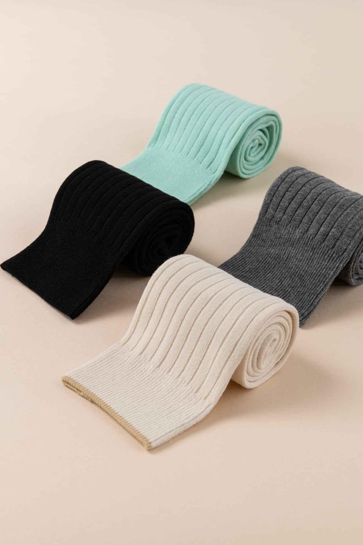 Love Classic ribbed socks in black, cream, grey, and mint displayed on a beige surface