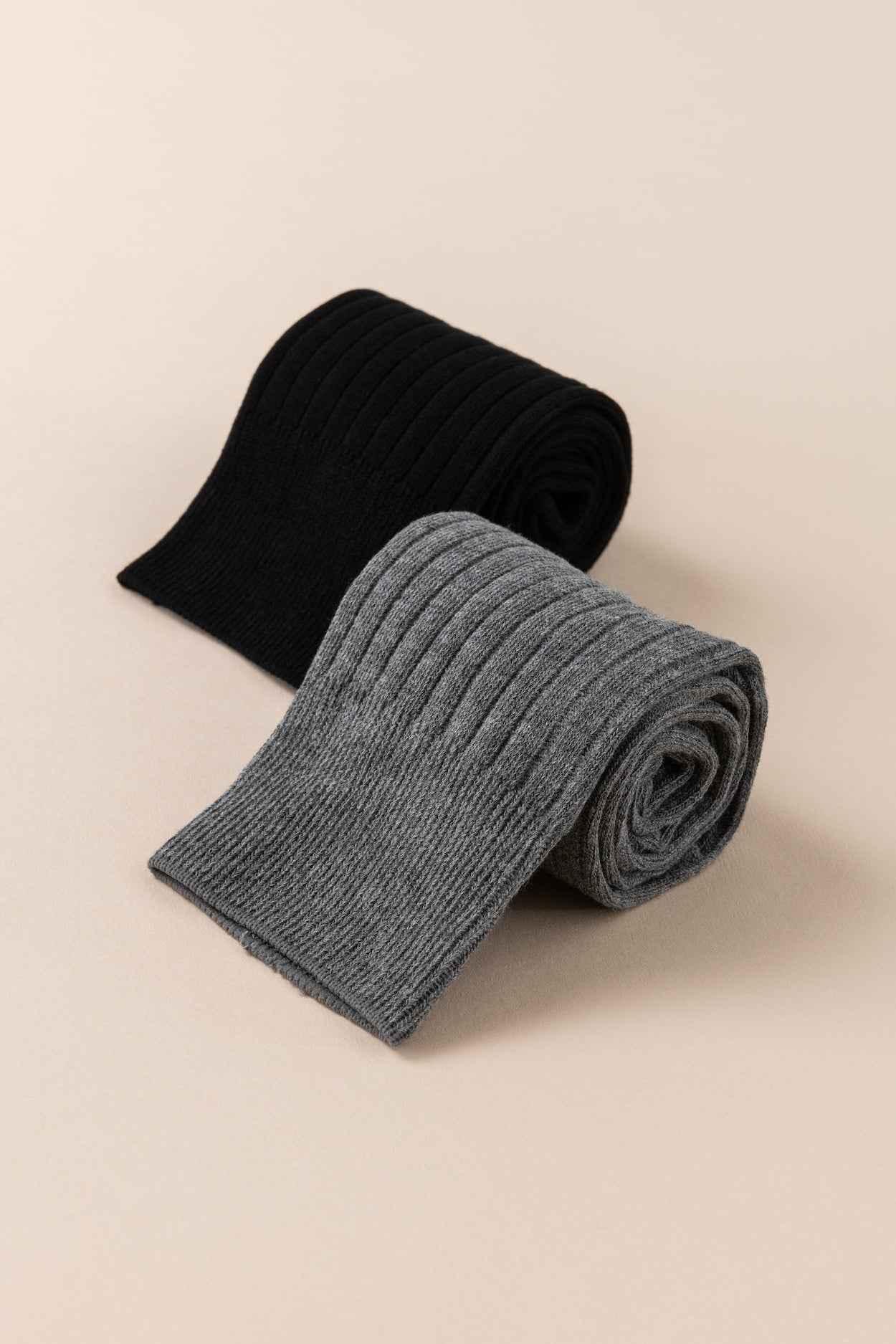 Love Classic ribbed black and gray knit socks rolled on beige background