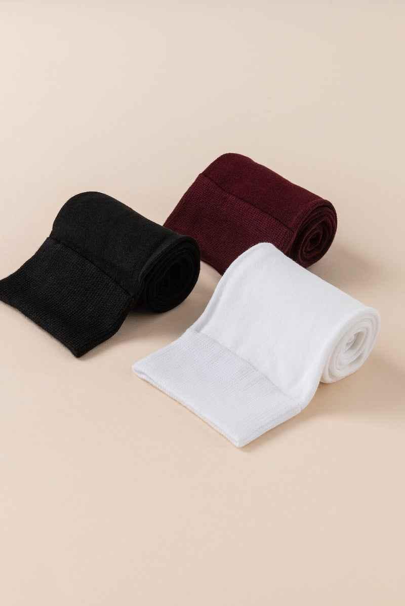 Three pairs of Love Classic tights in black, burgundy, and white on a neutral background.