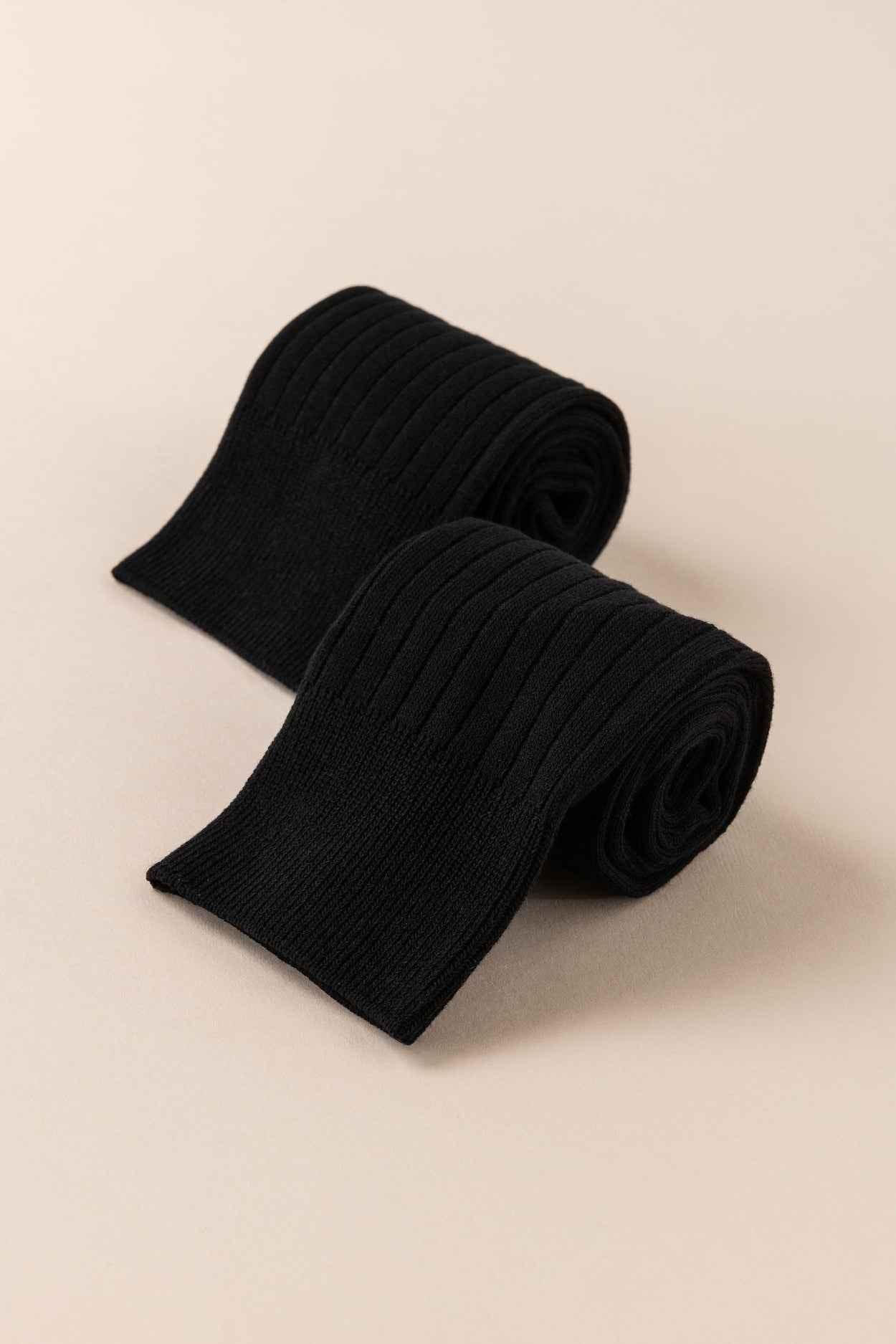 Love Classic black ribbed knit tights rolled on beige background