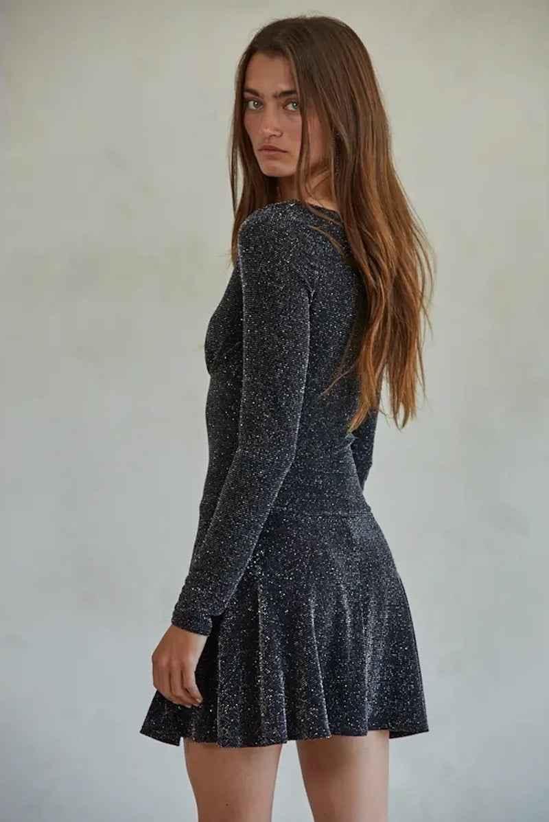 Woman in a sparkly long sleeve dress from Love Classic, stylish high quality fashion.