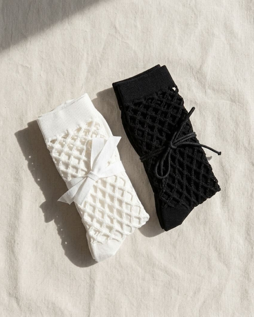 Bundled Pack, Midnight Lattice Fishnet Socks featuring breathable open mesh construction with a flexible crew fit and soft stretch comfort, worn in a lavender color variation beside a poolside setting with casual sneakers, highlighting lightweight comfort and relaxed seasonal styling.