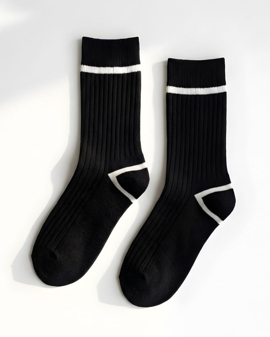 Classic Ribbed Crew Socks with Contrast Trim, black ribbed crew socks with white stripe detail at the cuff and geometric contrast at the heel, displayed flat against a clean neutral background to highlight texture and design.