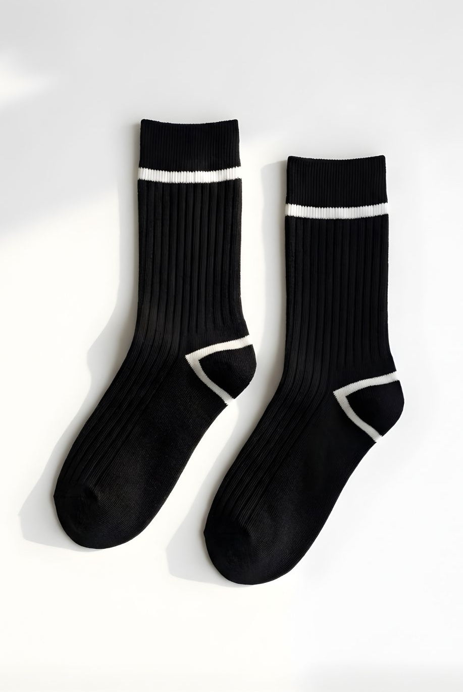 Classic Ribbed Crew Socks with Contrast Trim, black ribbed crew socks with white stripe detail at the cuff and geometric contrast at the heel, displayed flat against a clean neutral background to highlight texture and design.