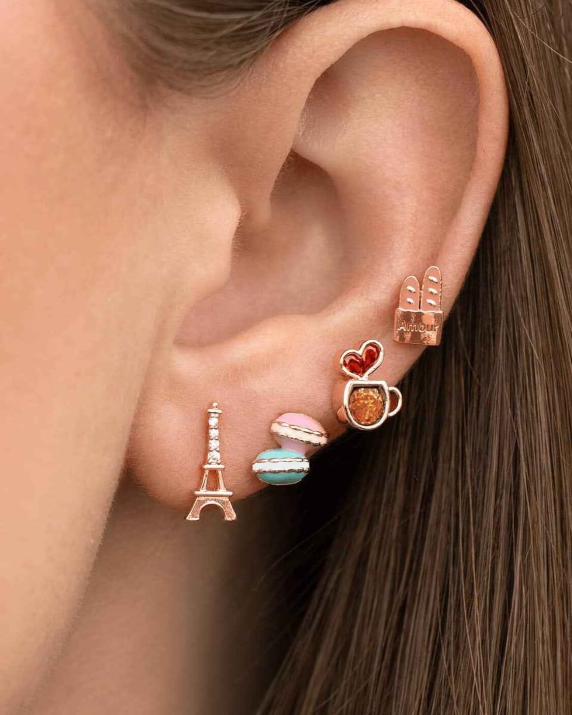 Café de Paris Stud Set featuring Eiffel Tower, macaron, coffee cup, and baguette inspired stud earrings with colorful enamel accents and polished gold tone edges, styled together in a close up ear stack, highlighting playful Paris themed jewelry and charming everyday styling