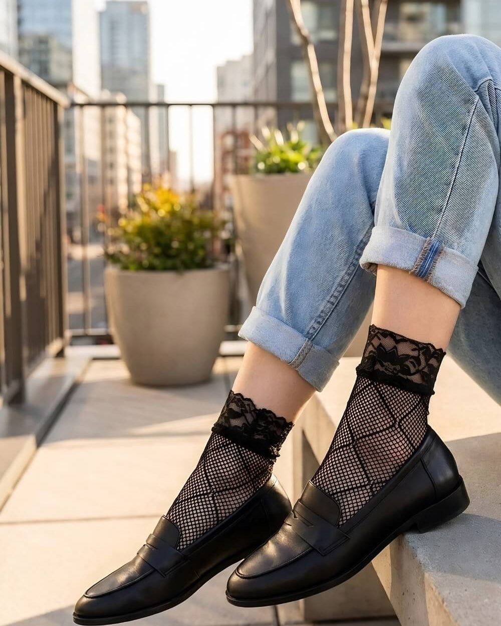 Diamond Lace Fishnet Socks featuring a fine fishnet weave with bold diamond-pattern detailing and delicate floral lace cuffs, styled with rolled light-wash jeans and black loafers on a rooftop terrace with a city skyline backdrop in warm golden sunlight for a chic street-style look.