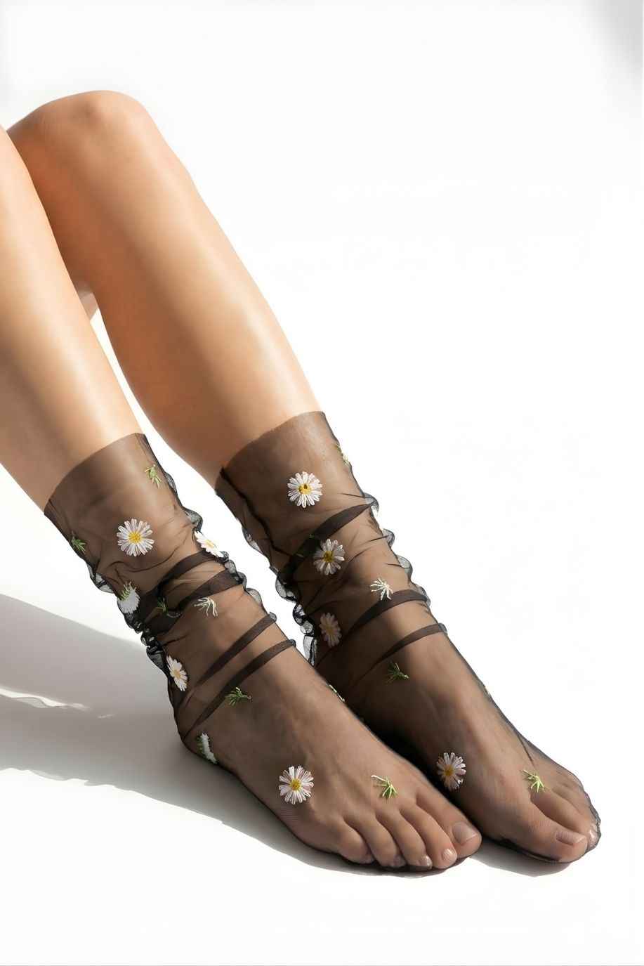 Sheer Garden Daisy Crew Socks in black sheer mesh with white and yellow daisy embroidery, displayed on feet to emphasize contrast and pattern.