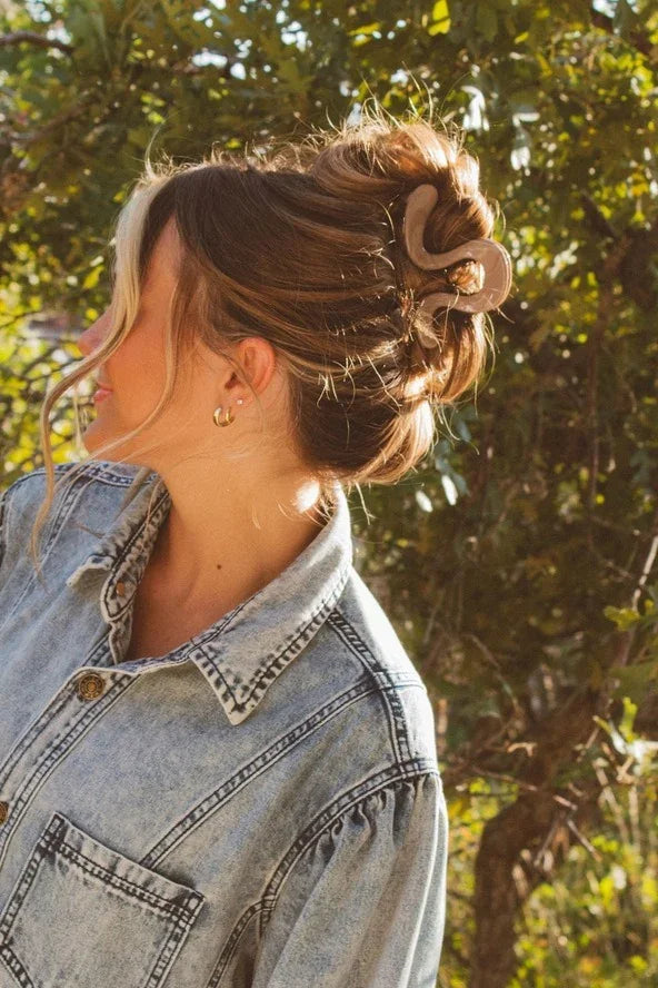 Woman in a denim jacket with hair in a claw clip, outdoors, Love Classic style