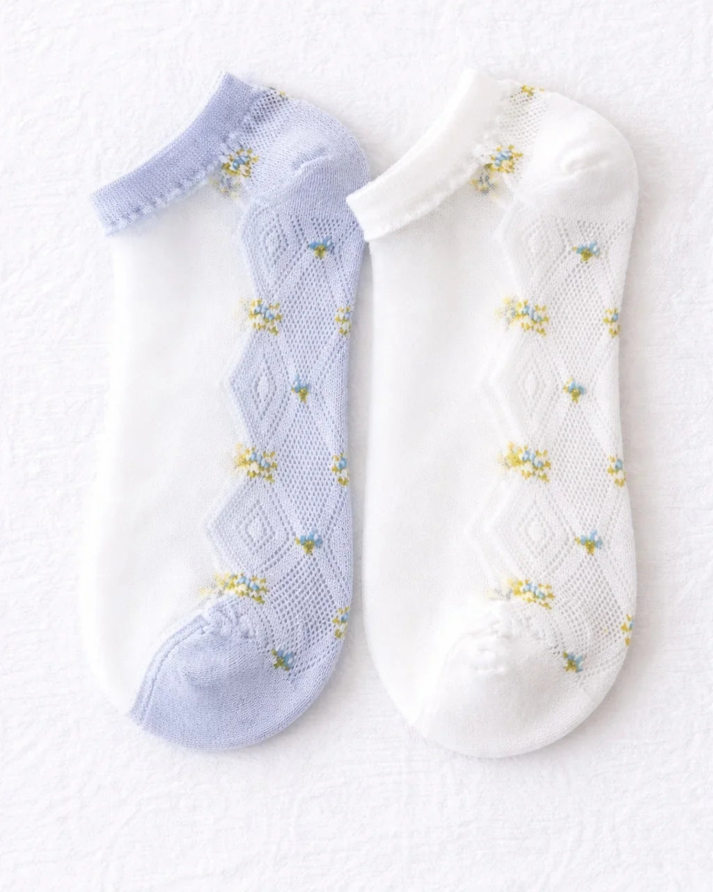Two pairs of low-cut braided floral socks in white and lavender on a white background