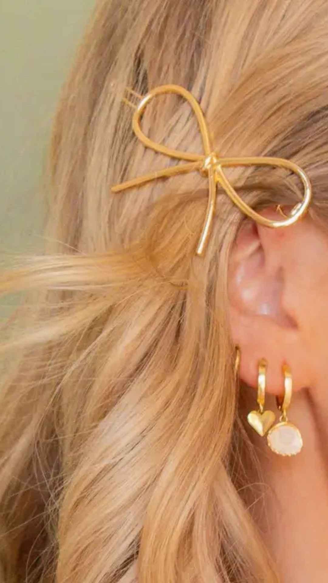 Gold bow hair clip and gold earrings on blonde hair, Love Classic high quality jewelry