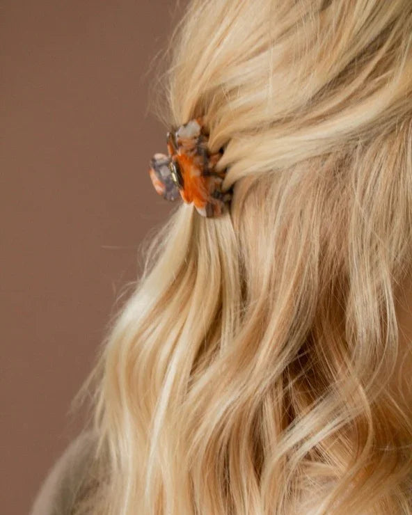 Blonde wavy hair styled with a small tortoiseshell hair claw clip