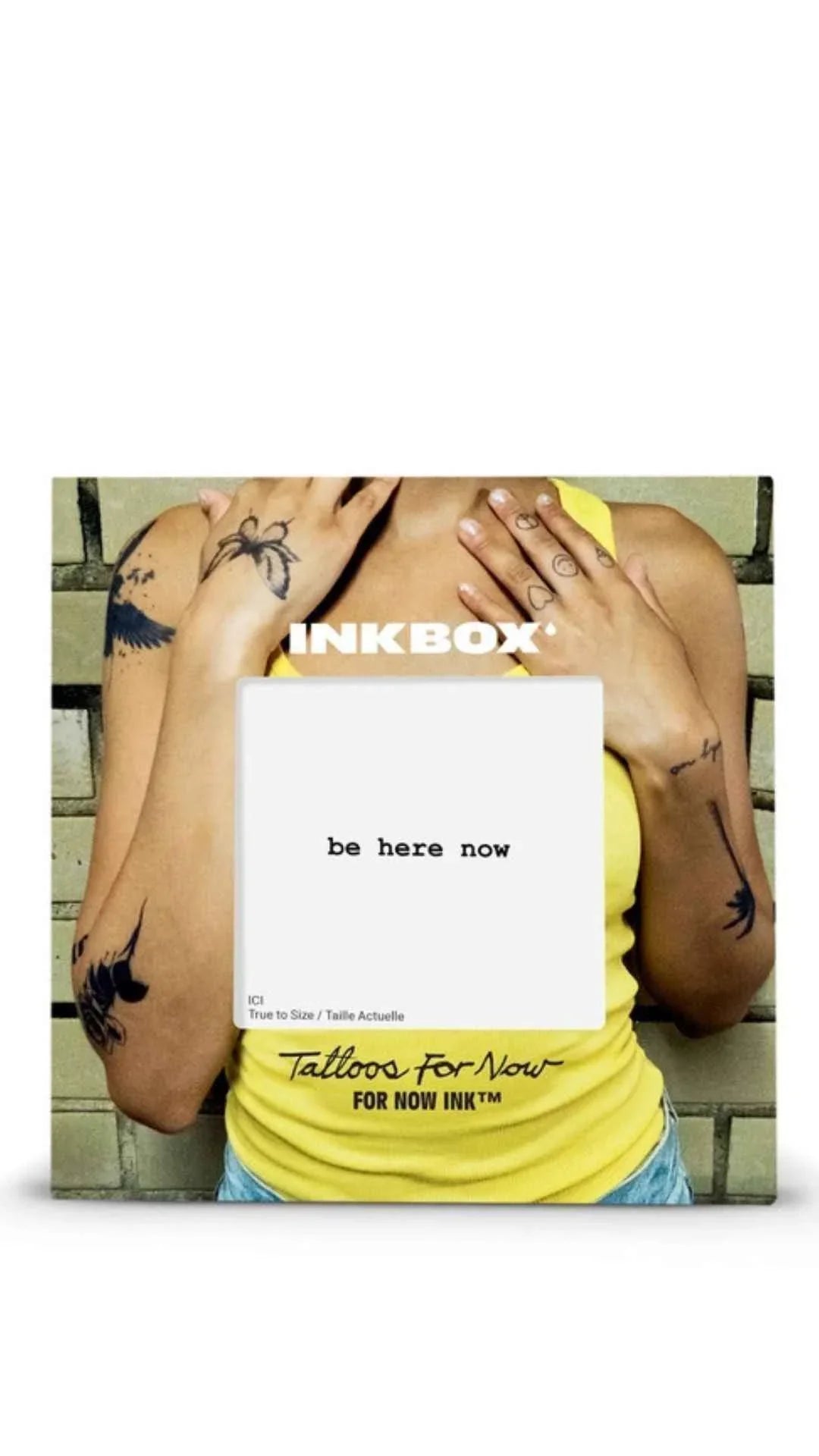 Person wearing yellow tank top with multiple temporary tattoos and text 'be here now' by Inkbox