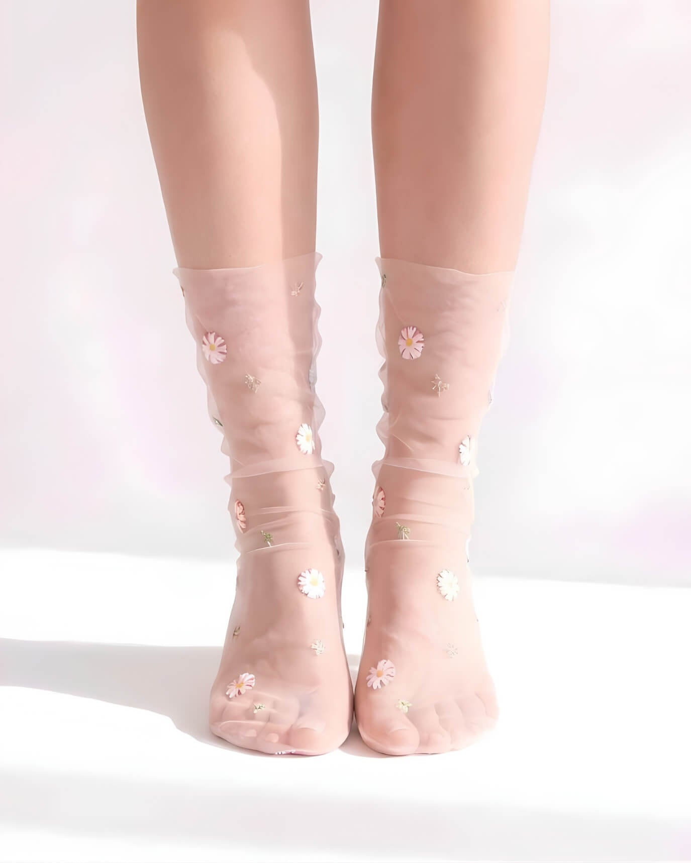 Sheer Garden Daisy Crew Socks in pink sheer fabric with scattered daisy embroidery, front view on both feet to showcase floral detailing and soft texture.