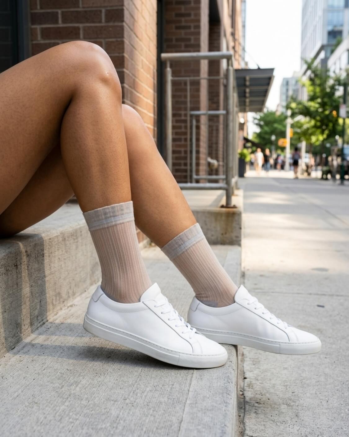 5-Pack Soft Horizon Sheer Socks featuring a fine sheer ribbed knit with contrast cuffs, paired with white trainers while seated on city steps, highlighting a lightweight fit for everyday wear.