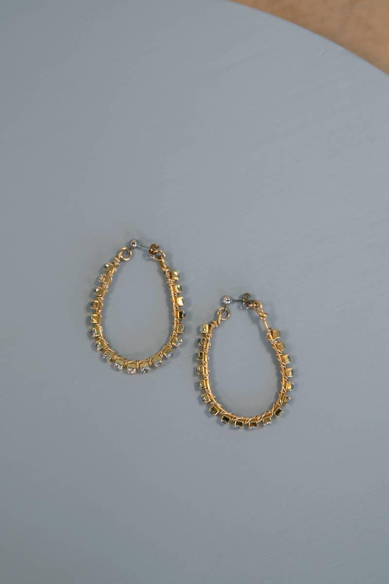 Gold hoop earrings with square accents on a light gray surface, Love Classic jewelry
