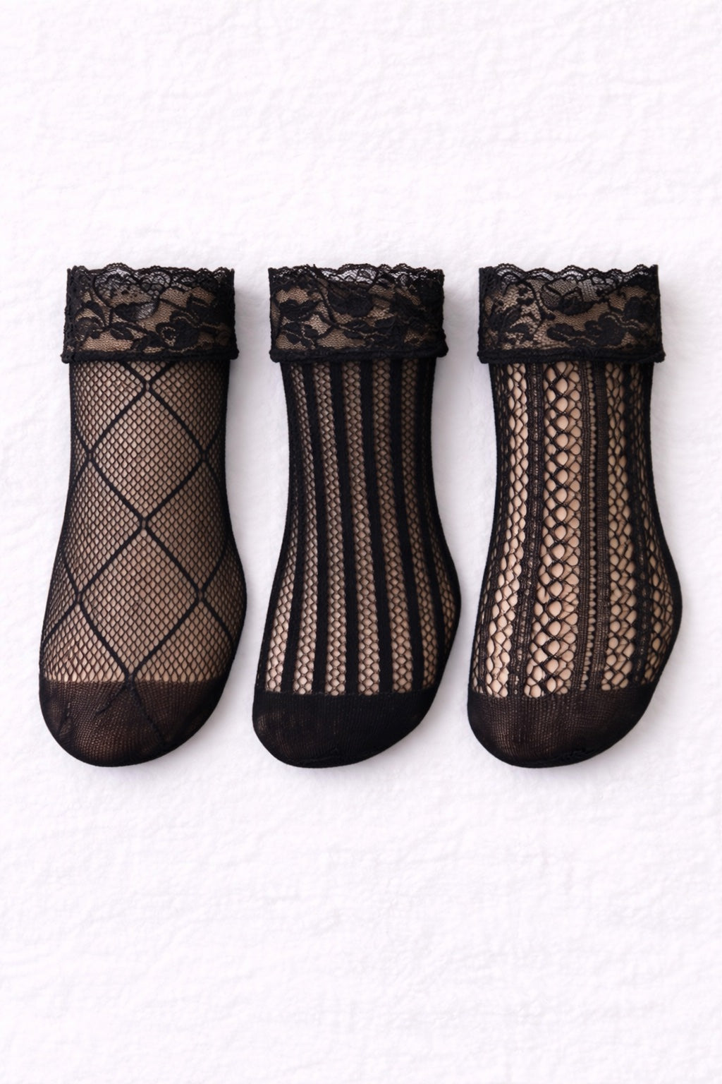 Three black lace fishnet ankle socks with floral lace cuffs displayed flat, featuring diamond, vertical stripe, and intricate lace patterns.