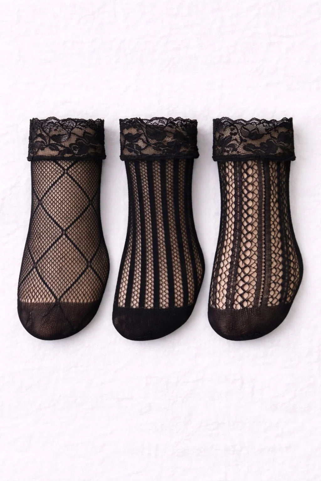 Three black lace fishnet ankle socks with floral lace cuffs displayed flat, featuring diamond, vertical stripe, and intricate lace patterns.