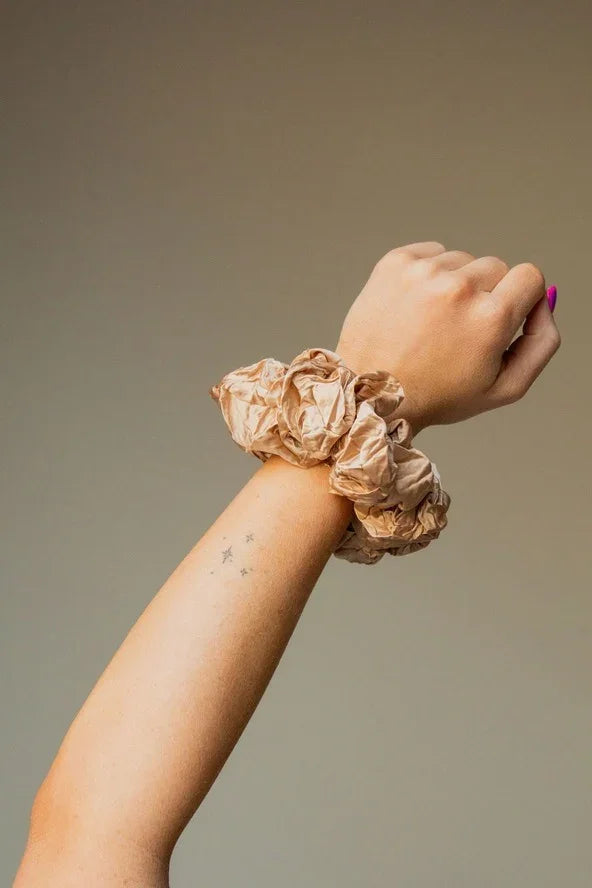 Woman's arm with beige scrunchies and star tattoos, Love Classic fashion accessory