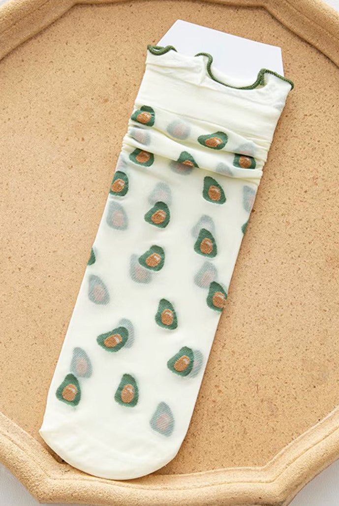 Sheer mesh crew socks featuring a playful pattern with a soft lettuce-edge cuff on a neutral background.
