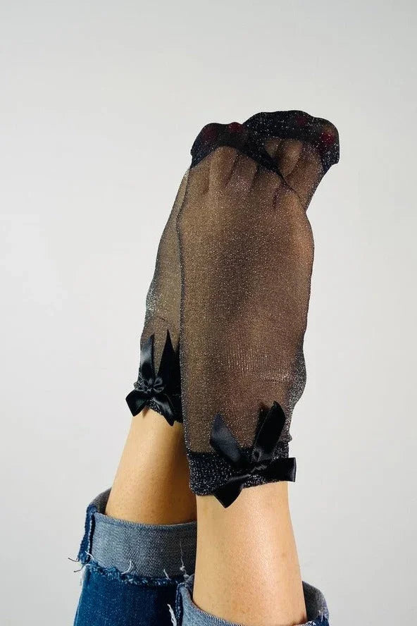 Black sheer glitter socks with satin bows, worn with rolled-up jeans, Love Classic style