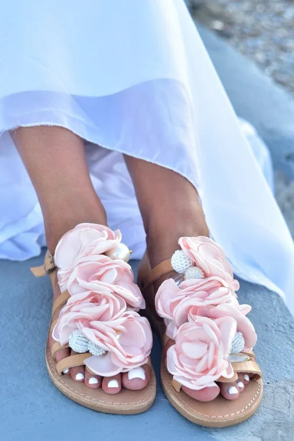 Woman wearing Love Classic pink floral sandals with pearls, white dress, outdoor setting