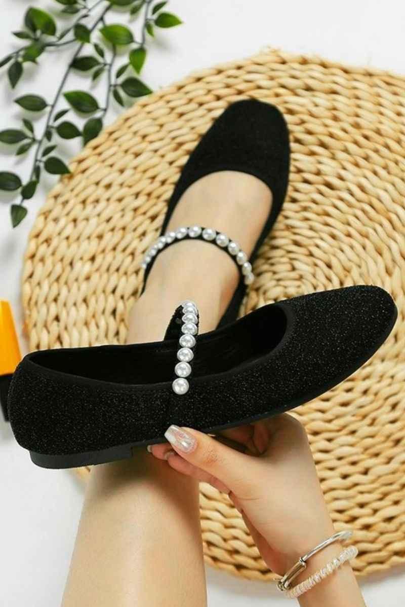 Black Mary Jane flats with pearl strap, Love Classic style, displayed on woven mat