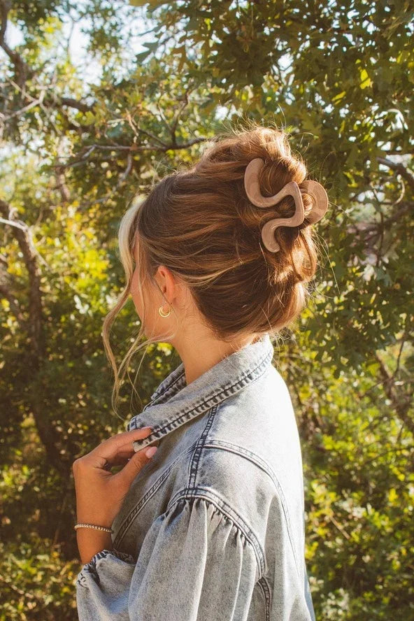 Woman with updo hairstyle and claw clip wearing denim jacket outdoors, Love Classic style