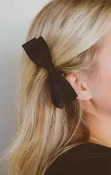 Blonde woman wearing a classic black hair bow accessory, Love Classic style