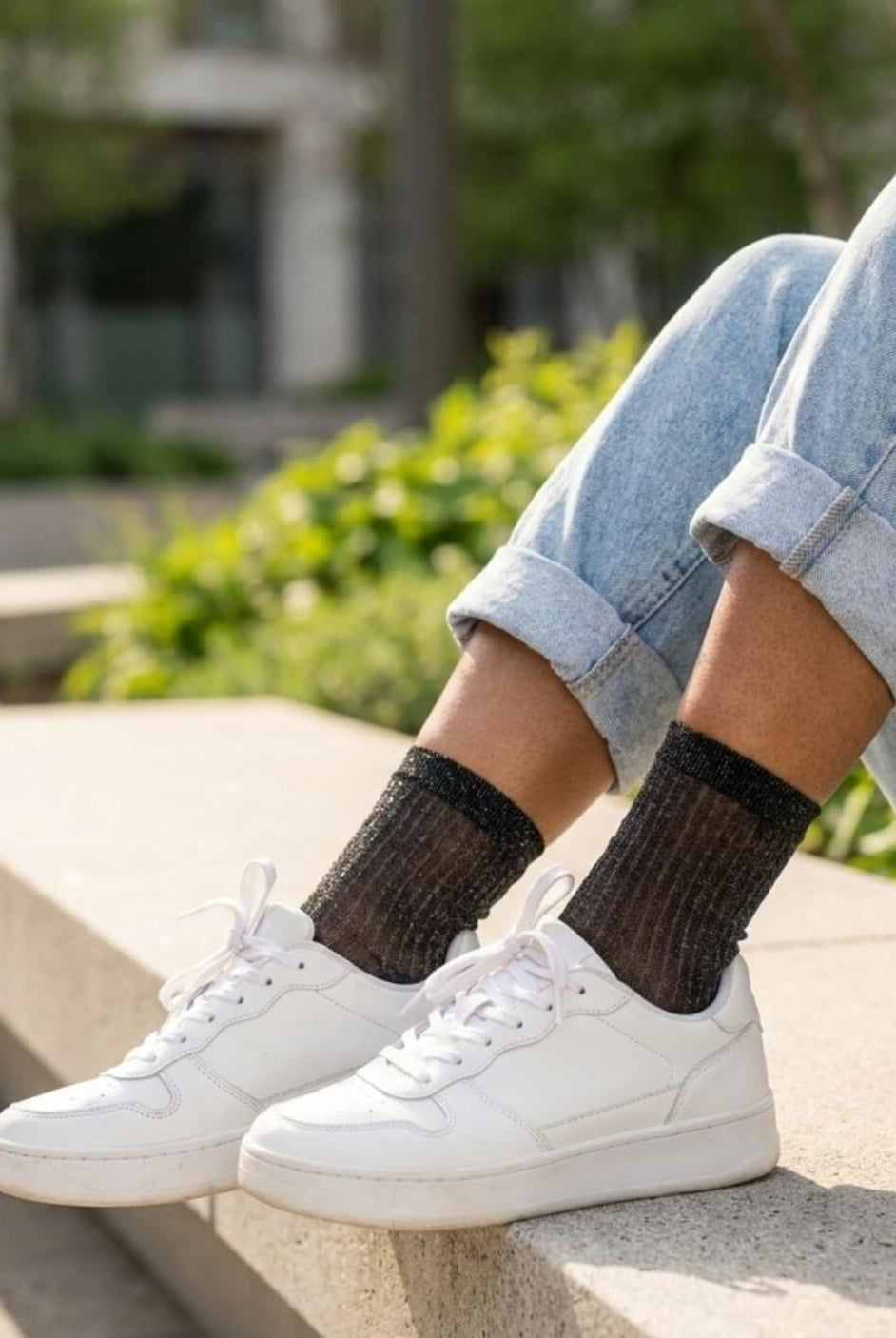 Sheer Metallic Ribbed Crew Socks in black with fine sparkle finish, paired with cuffed denim and white sneakers on outdoor steps, emphasizing the soft stretch fit and delicate ribbed detailing.