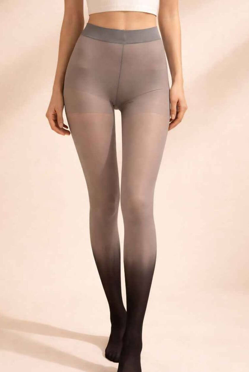 Gradient Sheer Tights featuring a translucent finish with a gradual ombré transition from soft gray to rich black at the feet, styled with a fitted cropped tank in a softly lit studio setting that enhances the smooth stretch fabric and modern aesthetic.