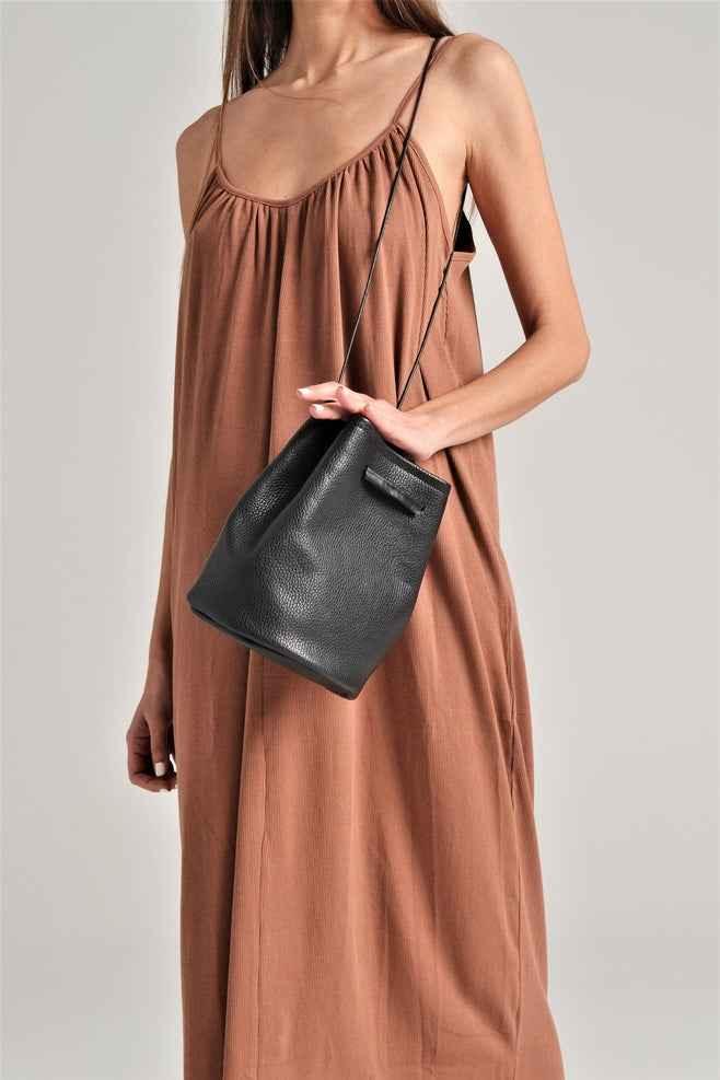 Woman in brown dress holding black leather bucket bag, Love Classic style
