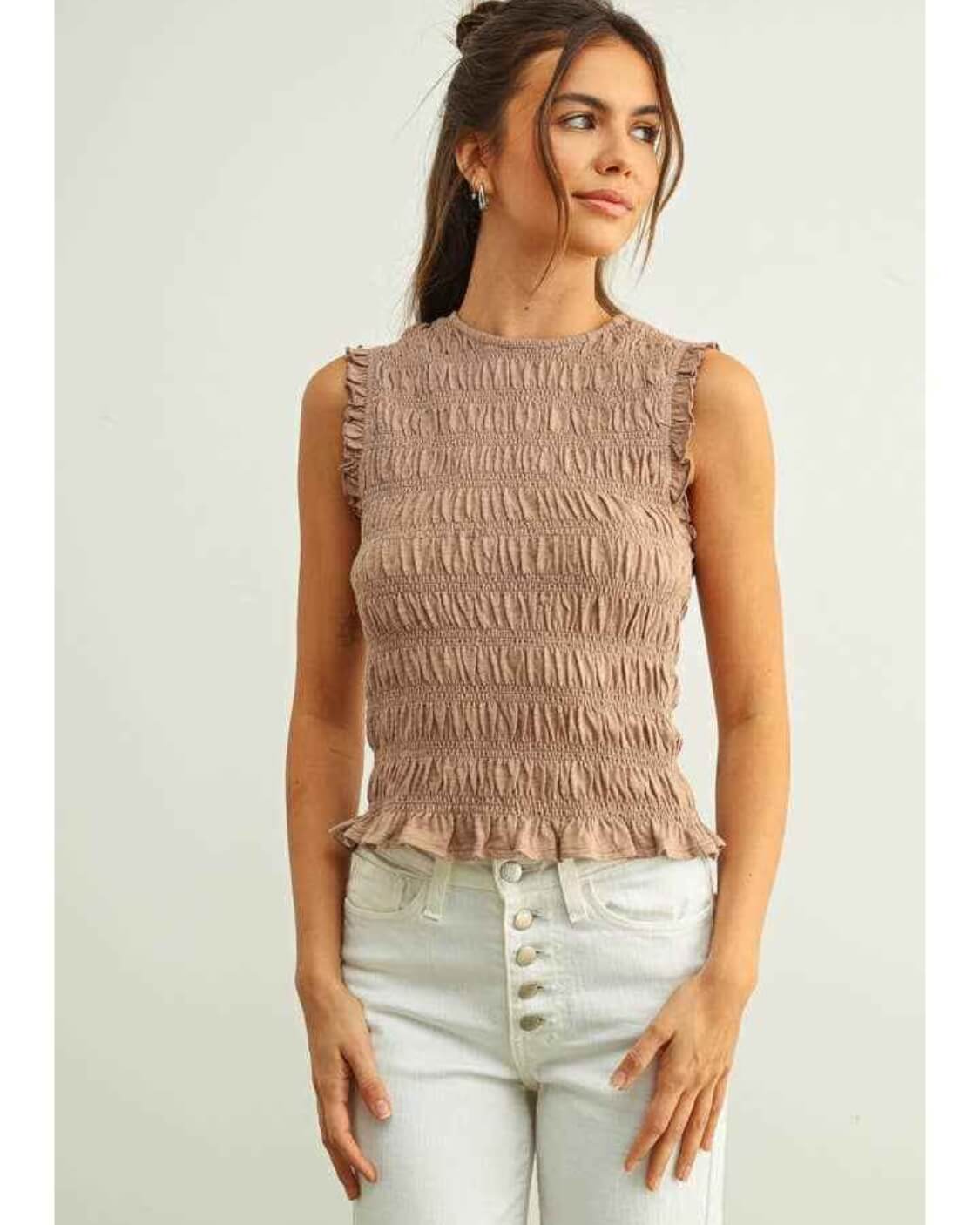 Sleeveless with All Over Smocking Top featuring all over gathered smocking with a fitted sleeveless cut and subtle ruffle hem detailing, paired with cropped button front jeans in a front standing pose against a minimal studio setting, emphasizing stretch fit and clean styling.