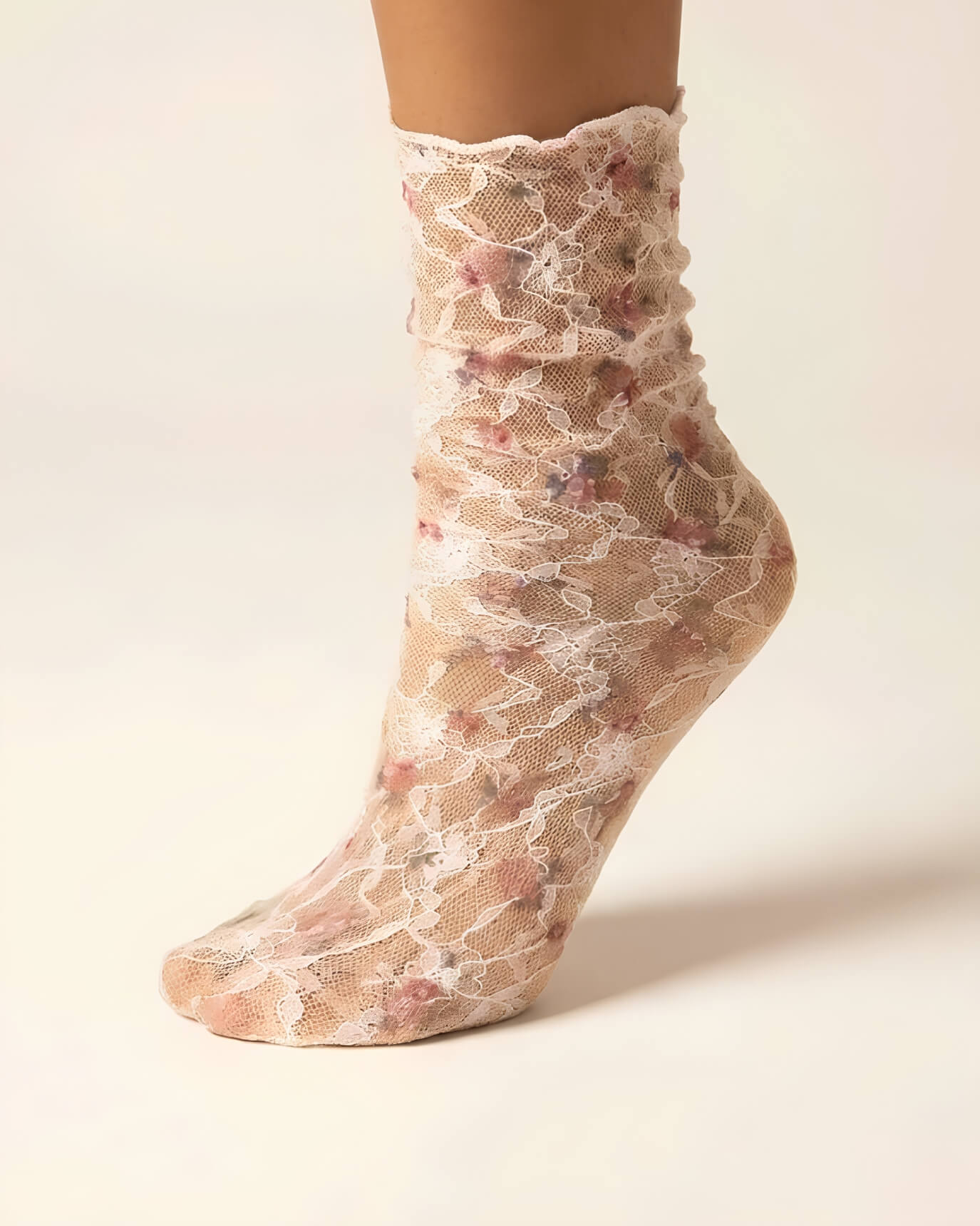 Floral Mesh Sheer Socks in pink floral lace mesh, shown on one foot with ruffled crew cuff and white lace detailing.