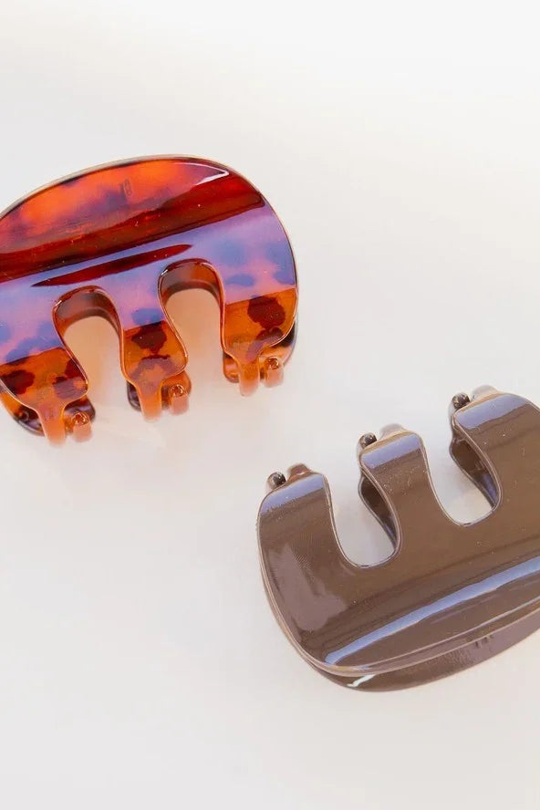 Two stylish Love Classic hair claw clips, one tortoiseshell and one solid brown, on white background