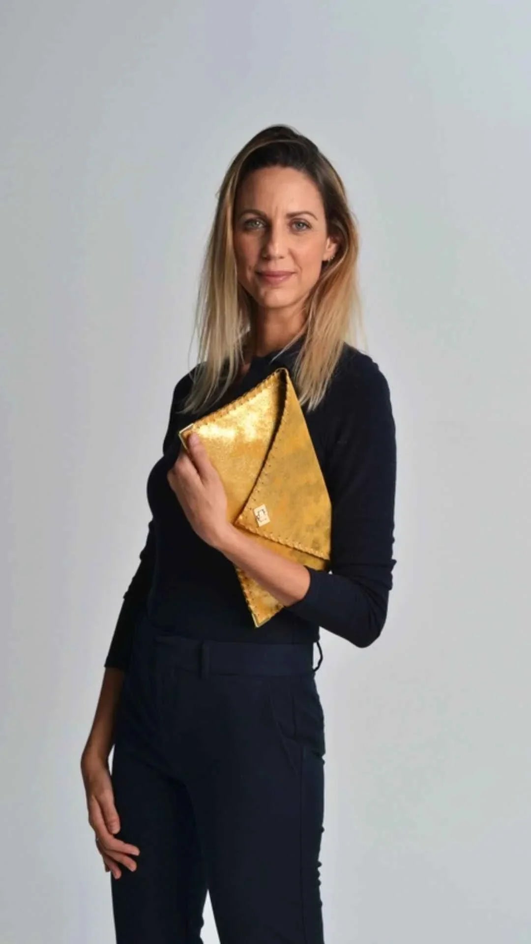 Woman in black outfit holding gold envelope clutch, Love Classic high quality style