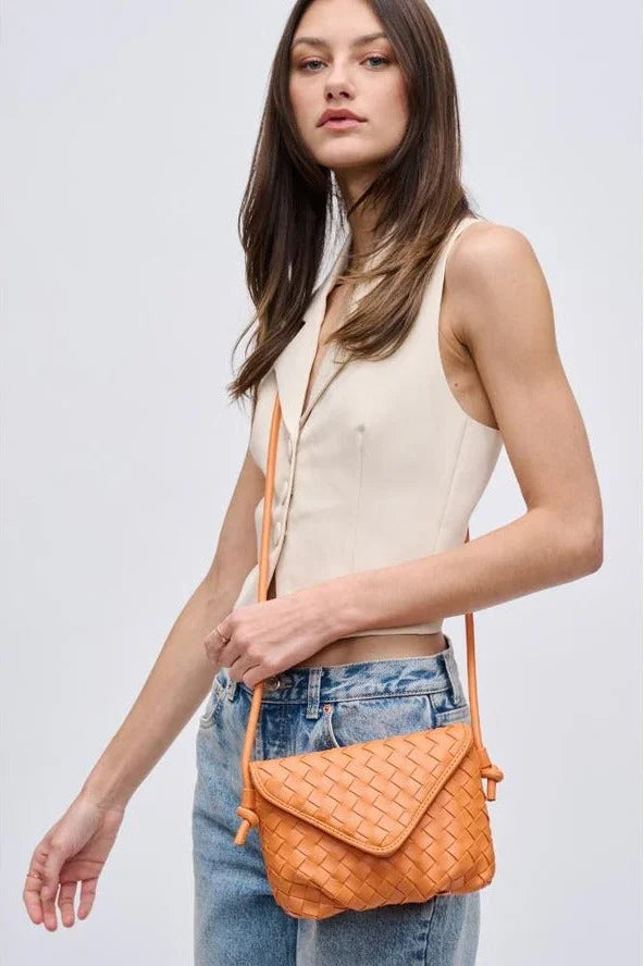 Woman in sleeveless beige top and jeans with orange woven crossbody bag, Love Classic style