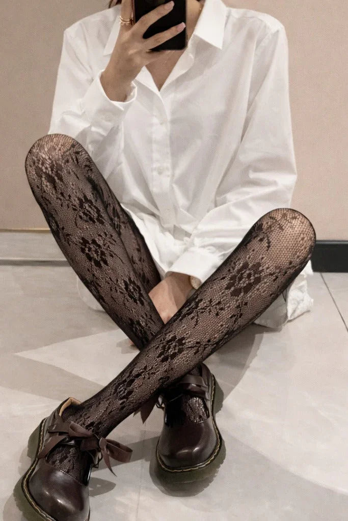 Close-up of black floral lace tights with semi-sheer texture and delicate pattern