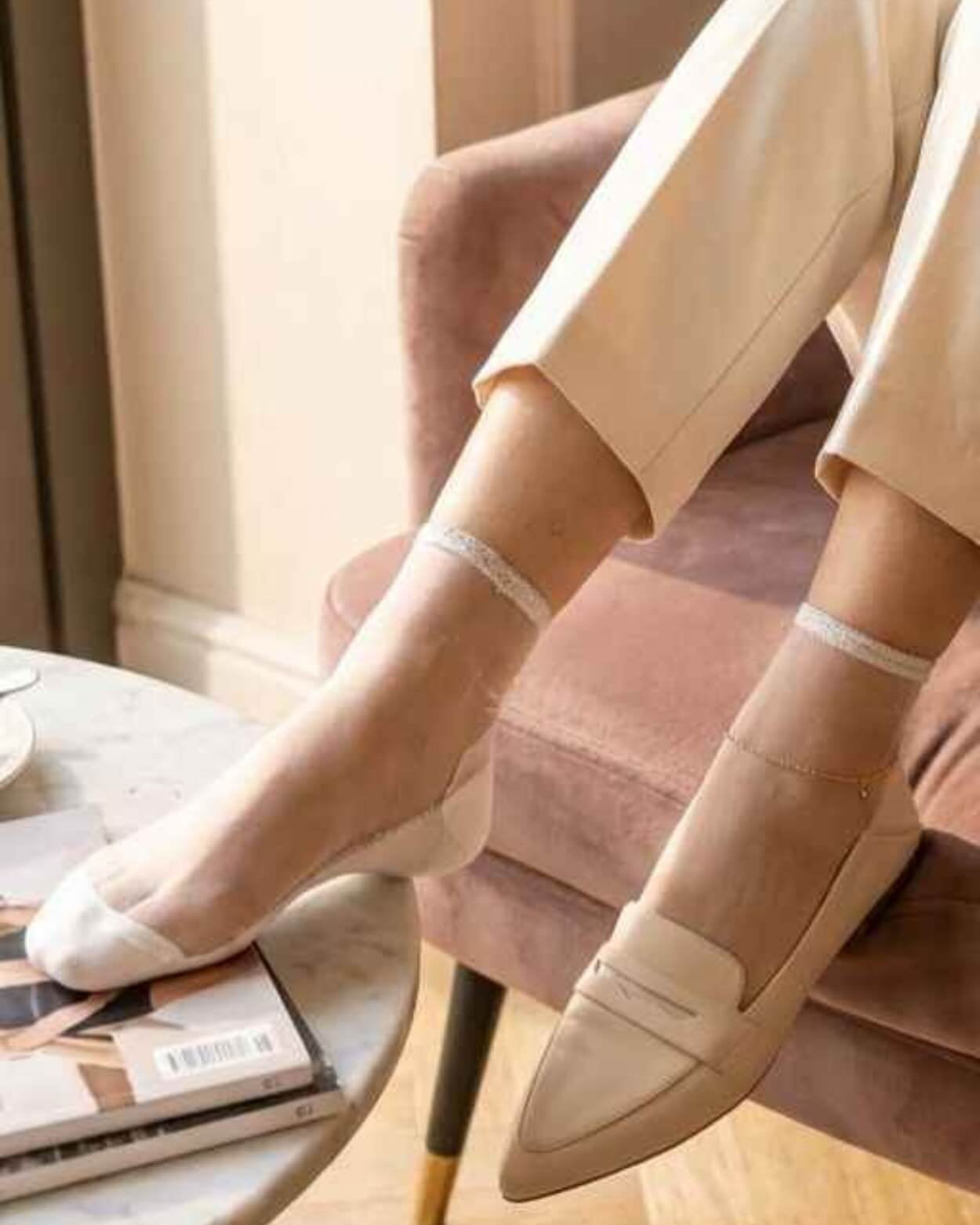 6-Pack Glitter Rim Sheer Crew Socks featuring transparent nude mesh fabric with silver glitter trim and reinforced white toe panels, paired with neutral loafers and cropped trousers in a sunlit indoor setting, highlighting elegant versatility and lightweight softness.