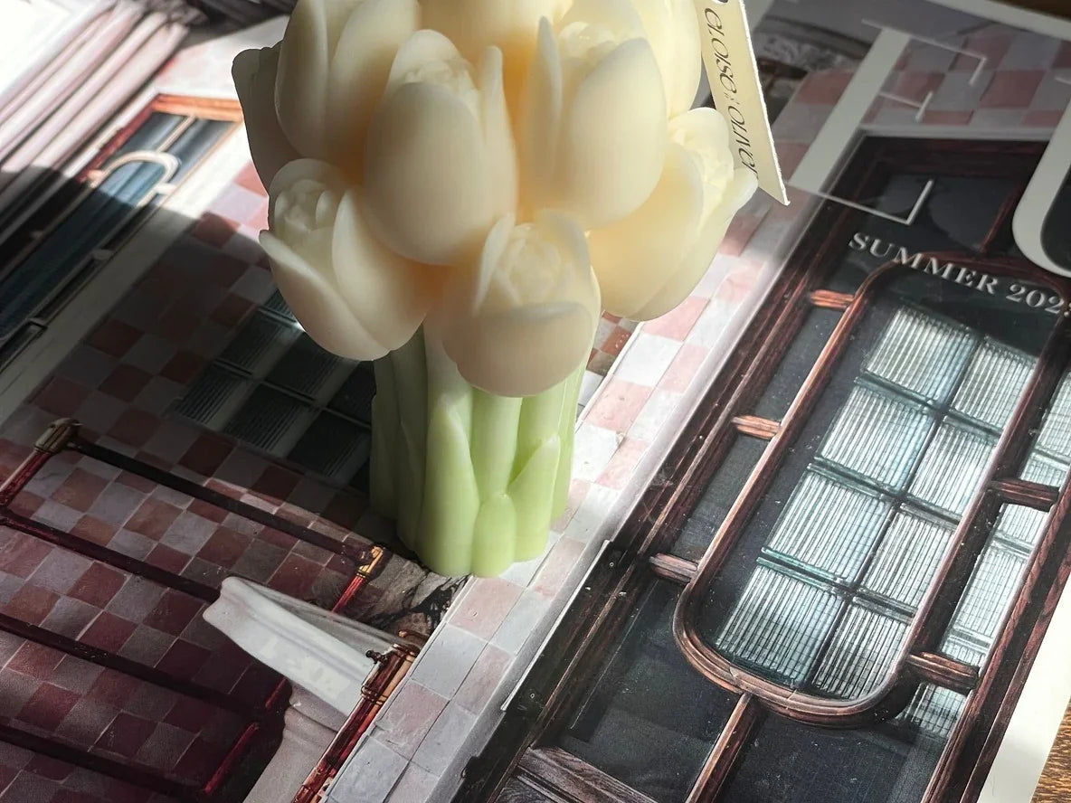 Cream tulip bouquet candle by Love Classic on a magazine, soft natural lighting