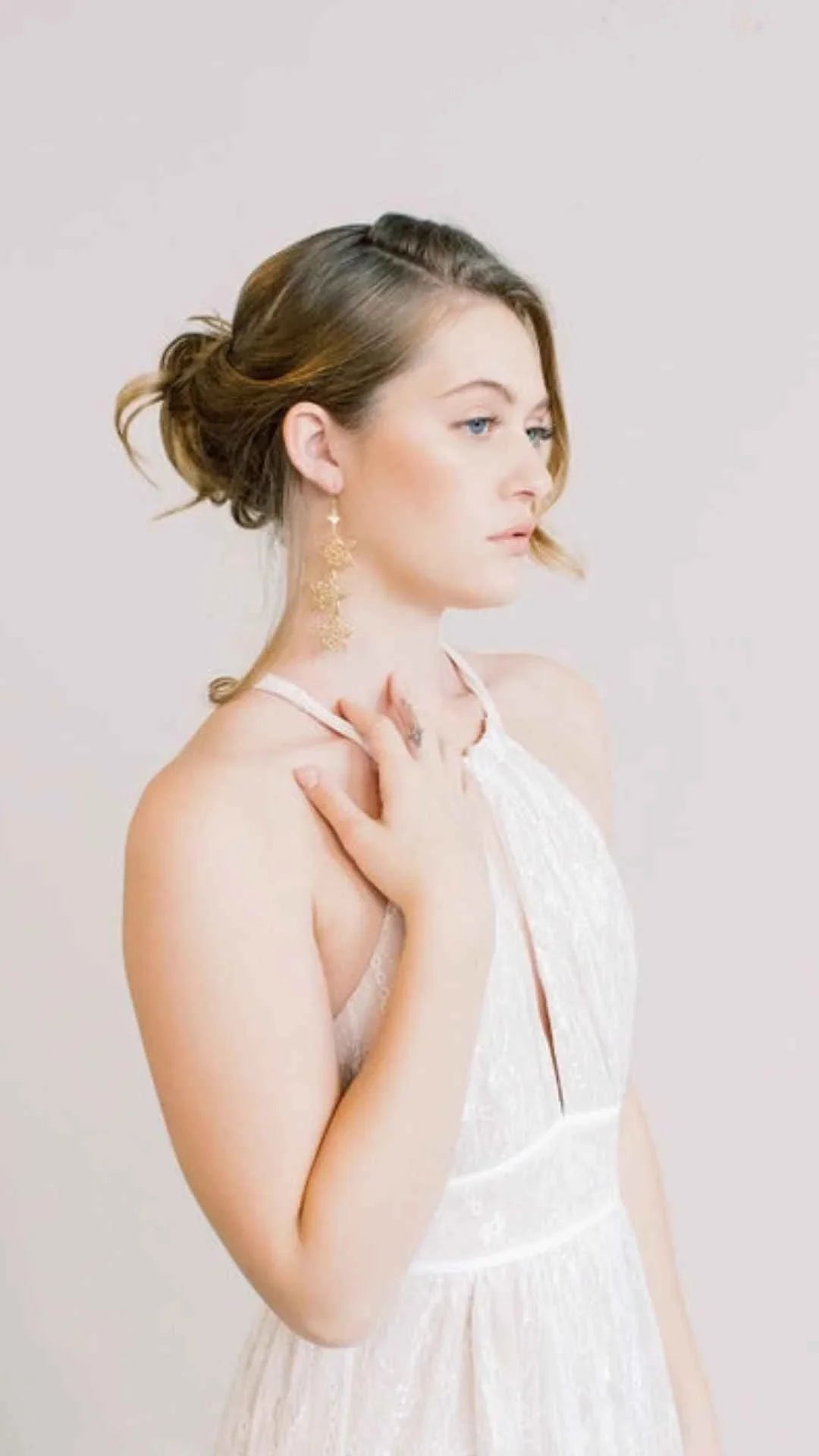 Woman in elegant white lace dress with gold statement earrings, Love Classic style