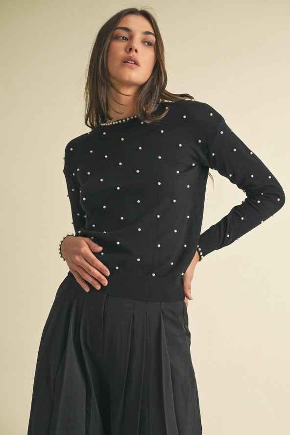 Woman wearing black pearl embellished sweater and pleated skirt, Love Classic fashion