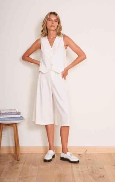 Woman wearing a white sleeveless vest and culottes, Love Classic high quality style, indoor setting