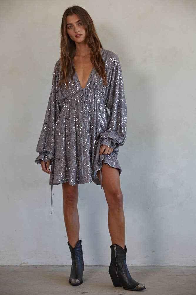 Woman in a sparkly silver sequin dress with long sleeves and black boots, Love Classic fashion