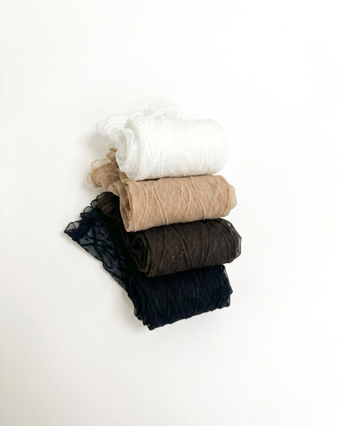 Bundled Packs Rosalie Lace Sheer Socks featuring raised wavy lace texture and delicate ruffled top edges, arranged in a clean stacked bundle with multiple rolled pairs, highlighting the sheer finish, compact storage and assorted pack styling.