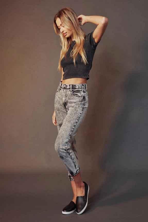 Woman modeling high-waisted acid wash jeans and black crop top, Love Classic fashion style
