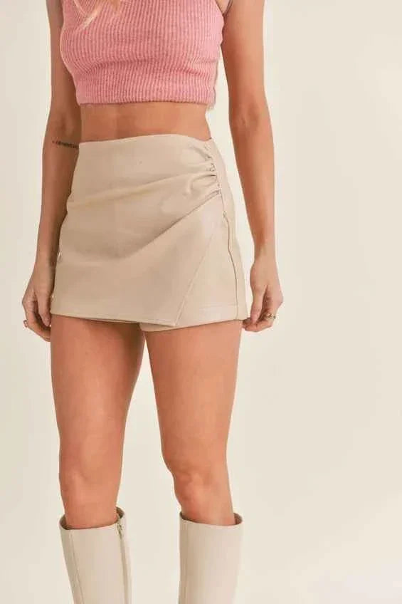 Woman modeling beige mini skirt, pink ribbed crop top, and cream boots, Love Classic fashion