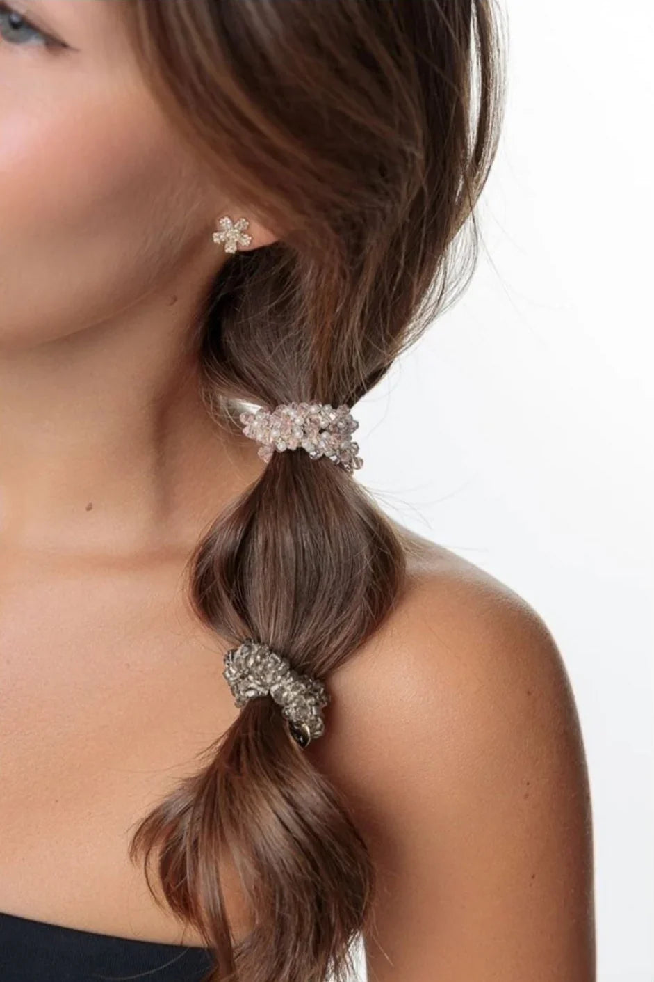 Woman with brown hair styled in a braid, wearing crystal hair ties and a flower stud earring, Love Classic style.