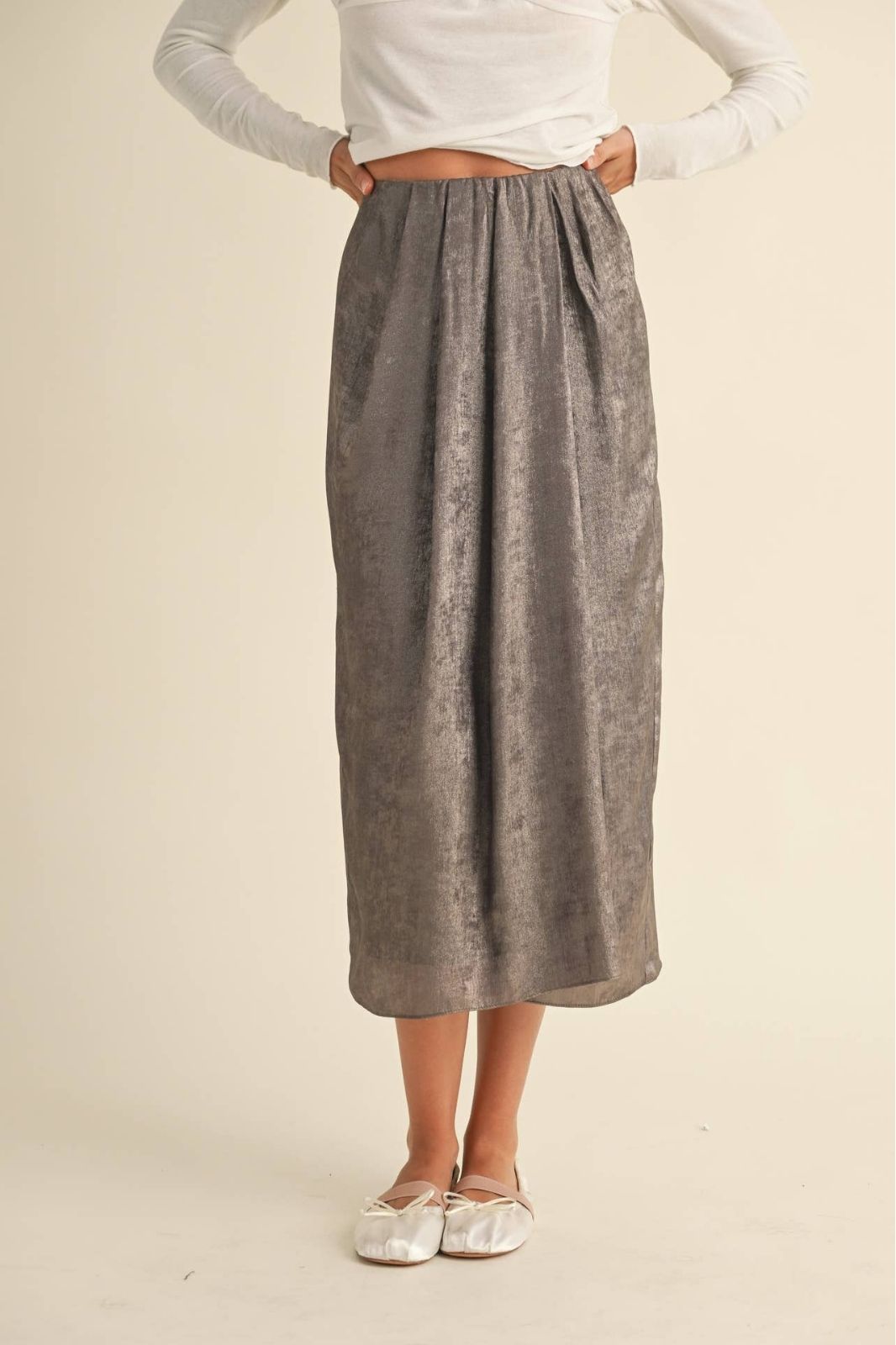 Metallic Fabric Pleat Detailed Skirt, front view showing the smooth high waist, straight midi silhouette, and metallic sheen styled with a fitted long sleeve top and ballet flats.