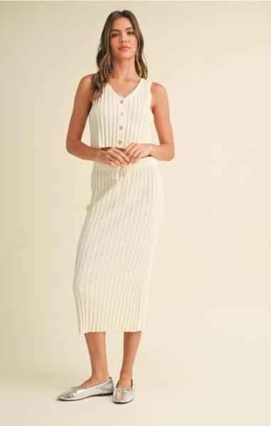 Woman wearing a sleeveless ribbed cream knit dress with buttons, Love Classic fashion style.
